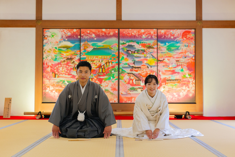 華やかな屏風の前で