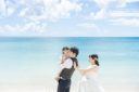 家族の笑顔が輝く沖縄フォト♡青い海とピンクの背景で残す幸せいっぱいのウェディング