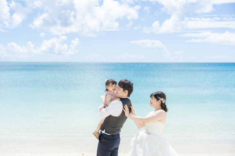 家族の笑顔が輝く沖縄フォト♡青い海とピンクの背景で残す幸せいっぱいのウェディング