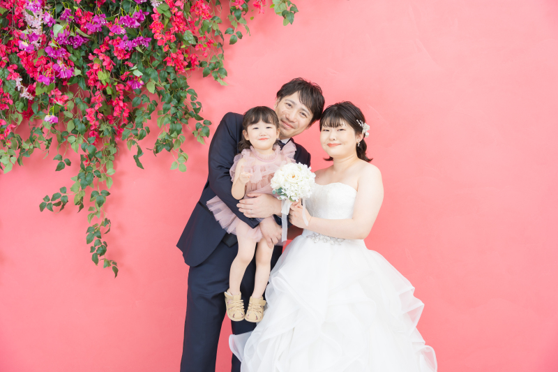 家族の笑顔が輝く沖縄フォト♡青い海とピンクの背景で残す幸せいっぱいのウェディング
