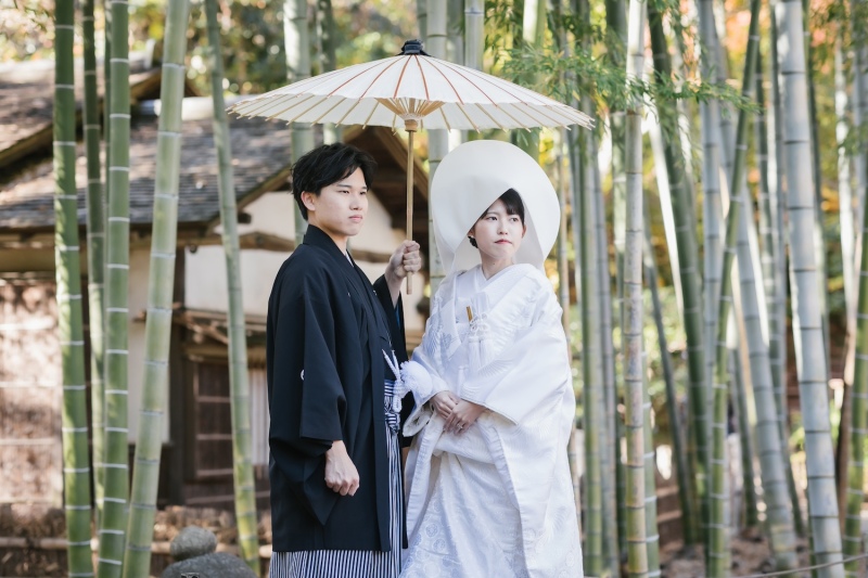 番傘を持って竹林のある素敵な庭園の前でのショット