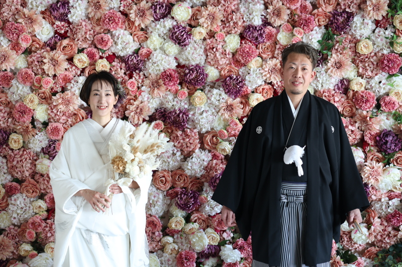 華やかなフラワーウォールをバックに