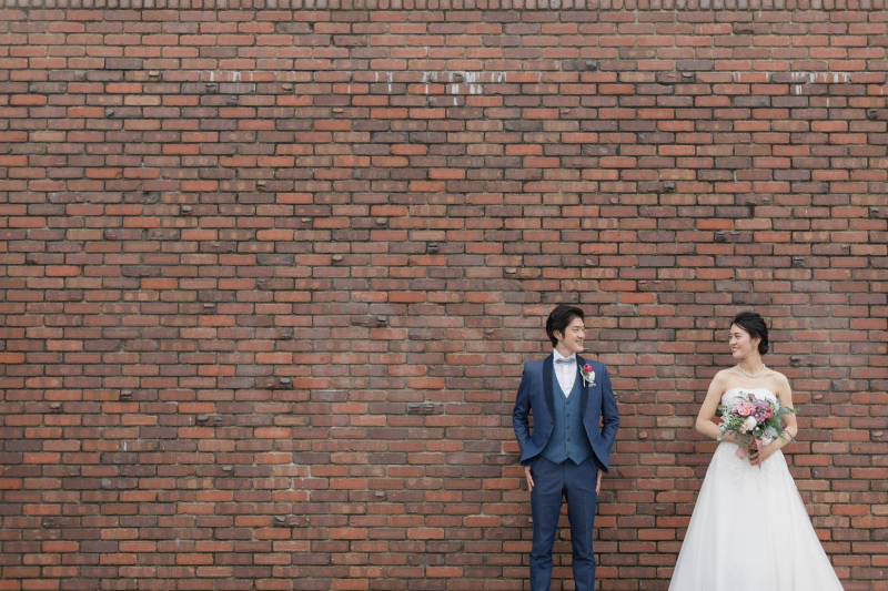 レンガの壁の前で