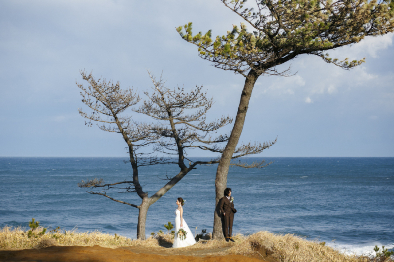 石川県の加佐の岬という場所でのワンシーン。日本海らしい天気とクールな二人のポージングがポイントです。