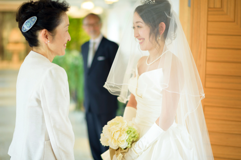 見つめあうふたり。その後ろでほほ笑むお父様