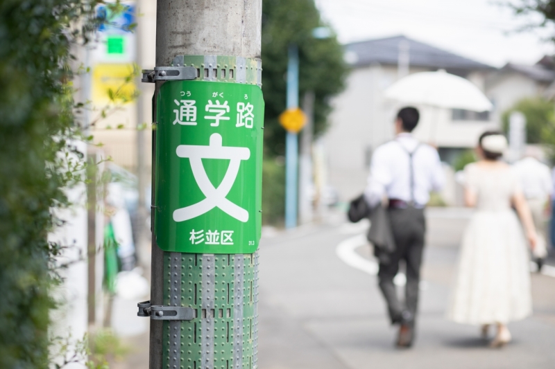 ウエディング姿で通学路を歩く