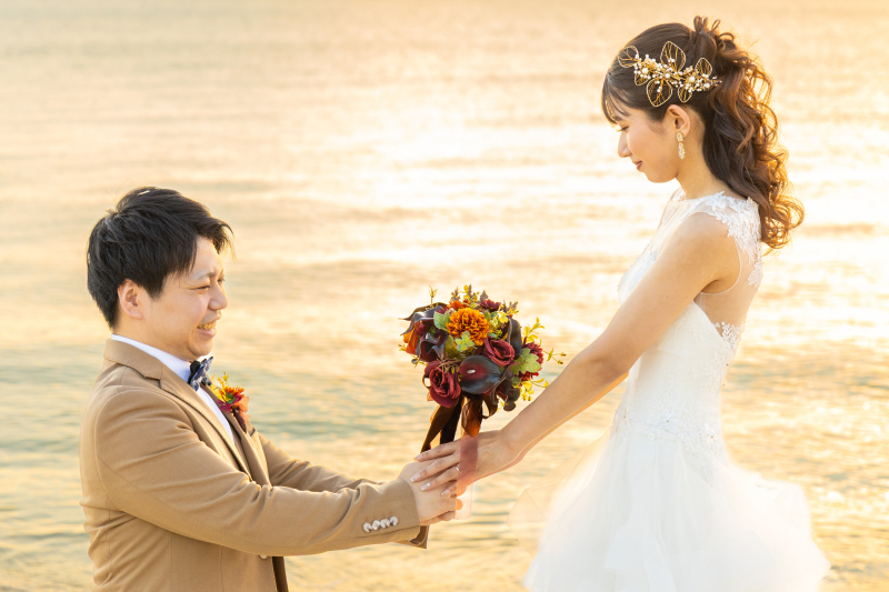 サンセットを背景にブーケをご新婦様に渡すシーン◎