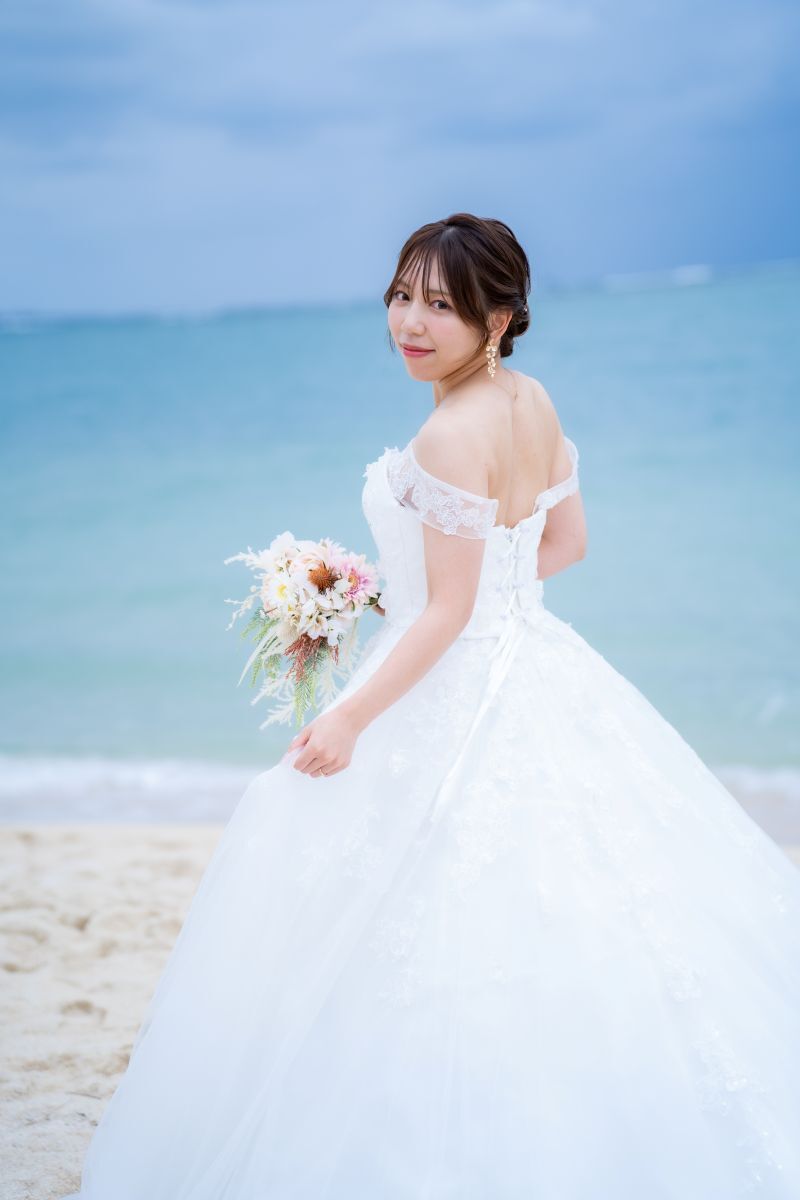 青い海を背景に映える純白のドレス姿