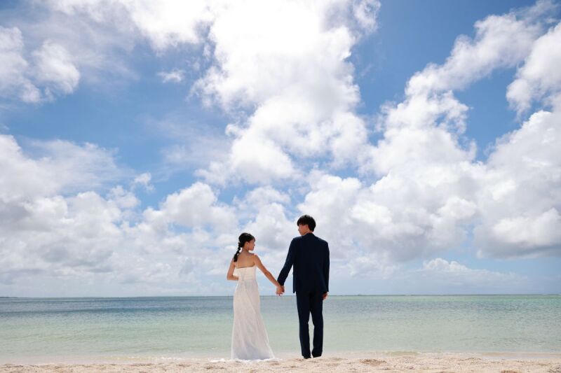 広いビーチに2人だけ、同じ方を見つめる未来への道