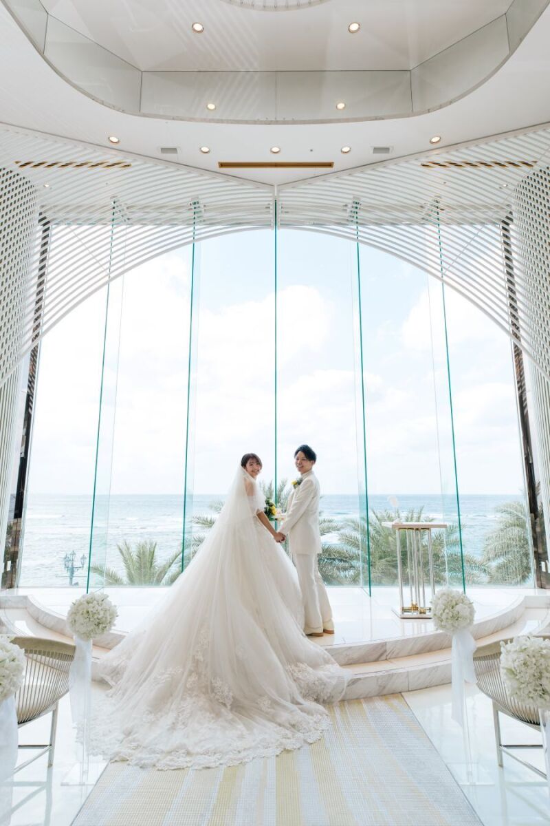 青い海を背に、未来へ手を取り笑顔で