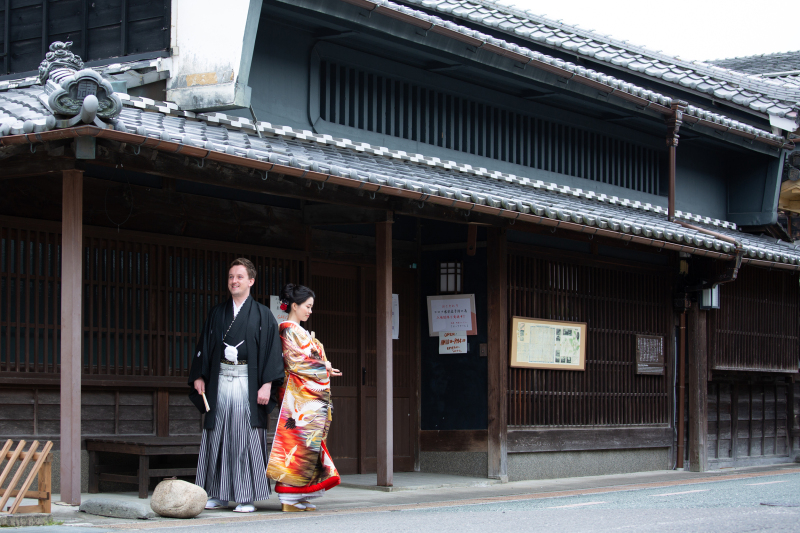 古い家屋を背景に