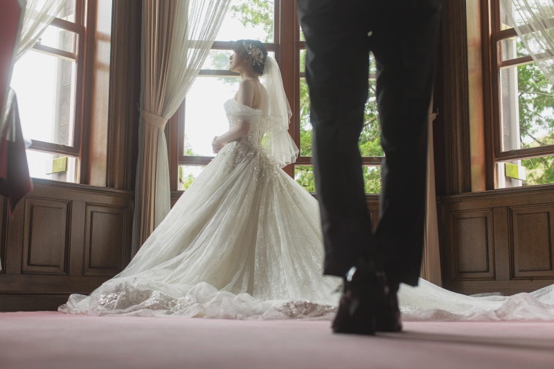 前ボケの新郎と窓辺にたたずむ新婦