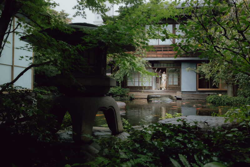 大きな石燈籠越しに見渡す、広大な日本庭園