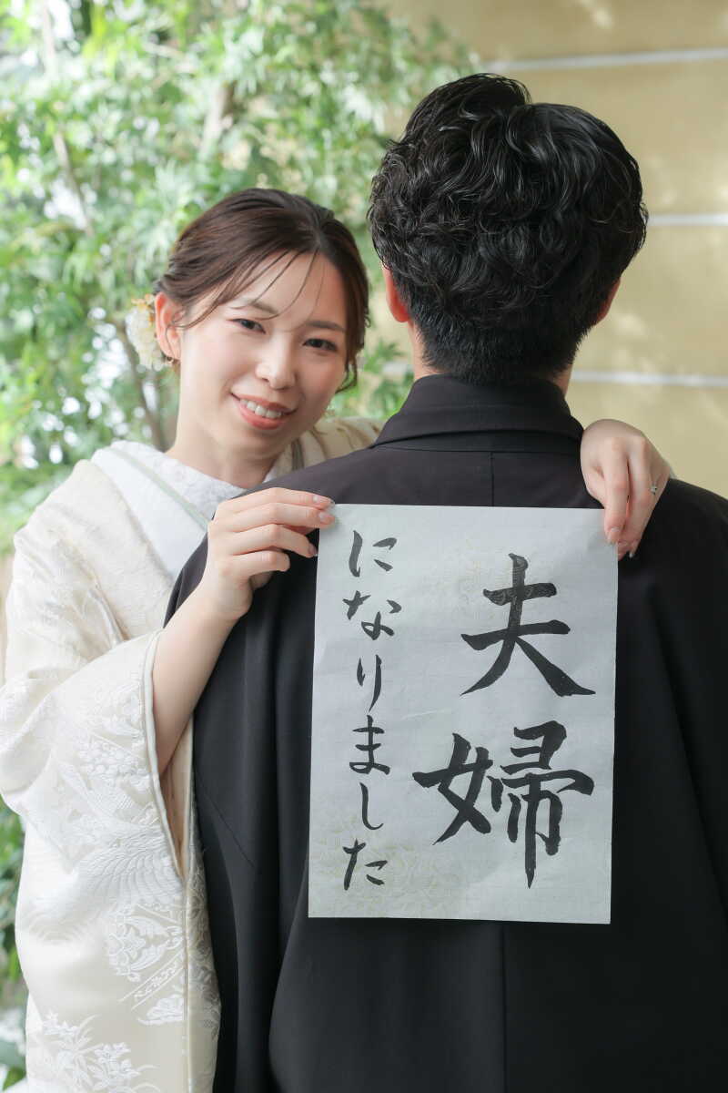 「夫婦になりました」の書を掲げたハッピーショット