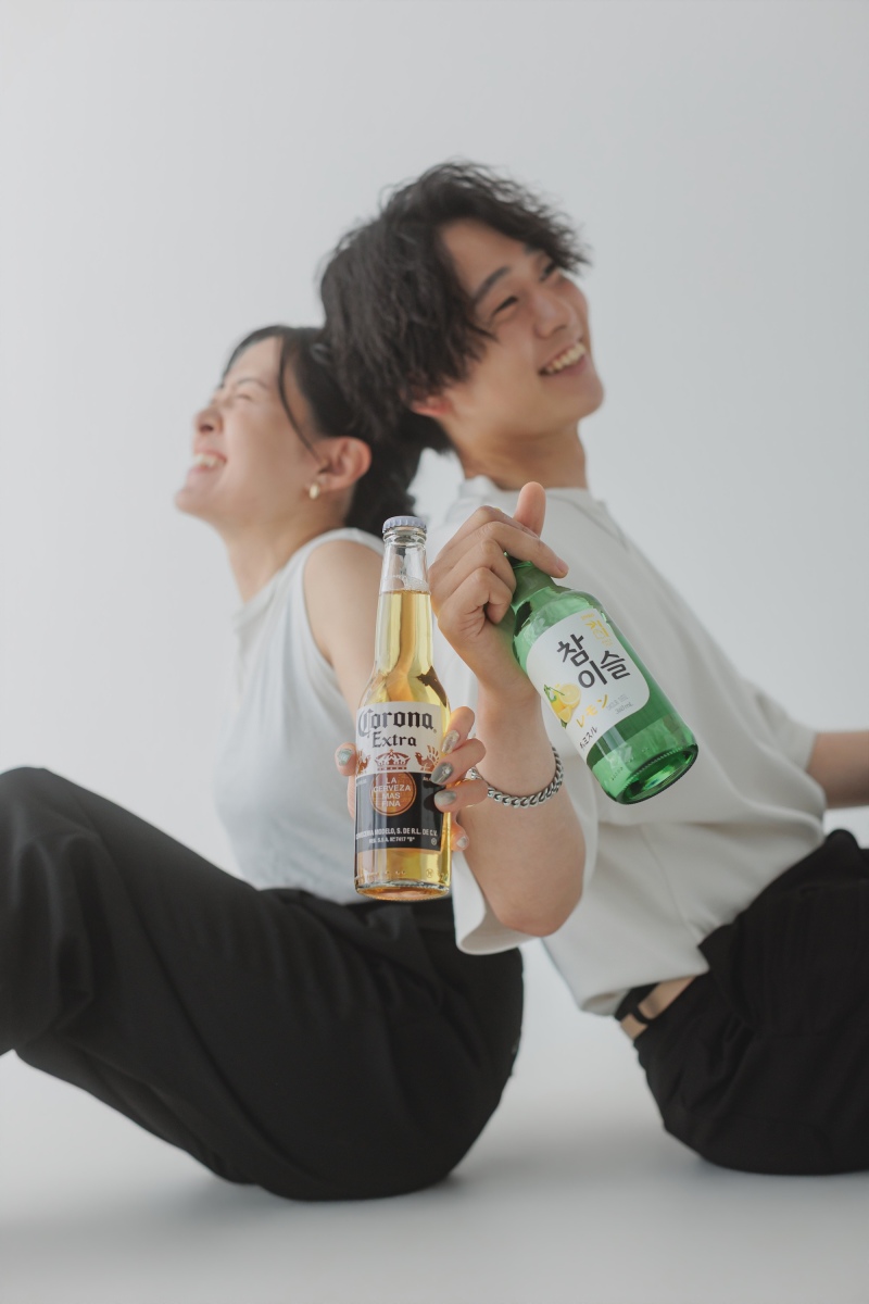 背中合わせで乾杯!お酒を手にしたリラックスカット
