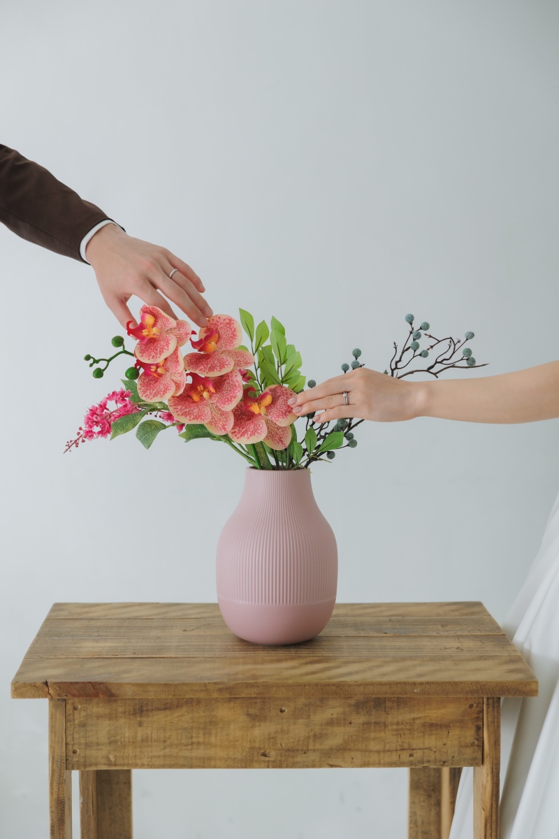 鮮やかな花器へ、手を伸びし合って