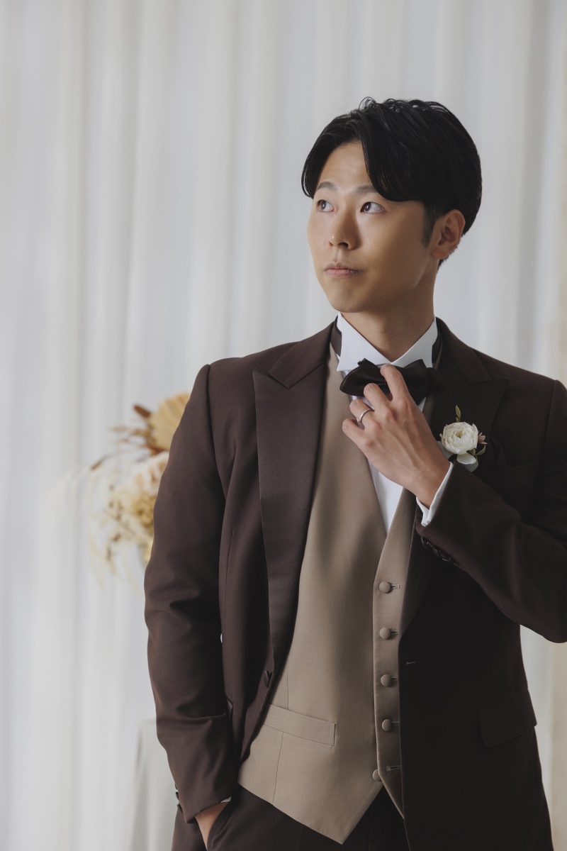 蝶ネクタイに手を添えて、スマートに
