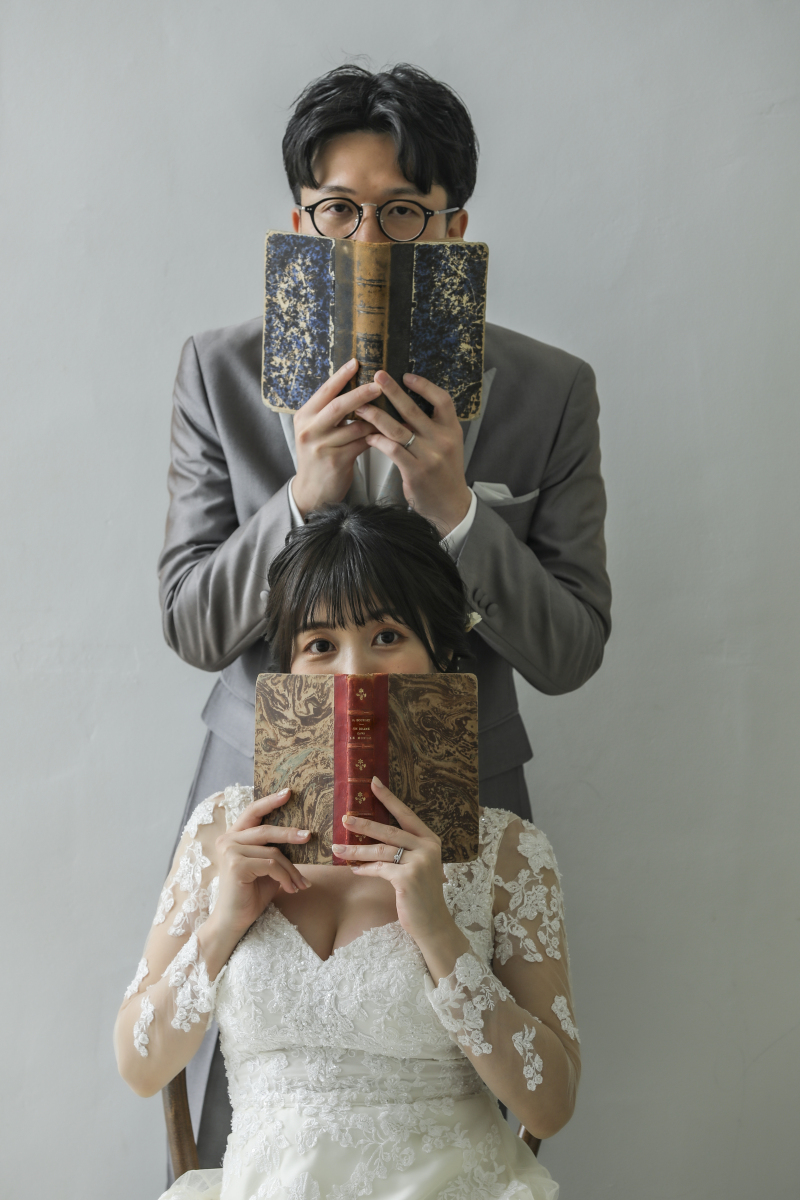 本で口元を隠して