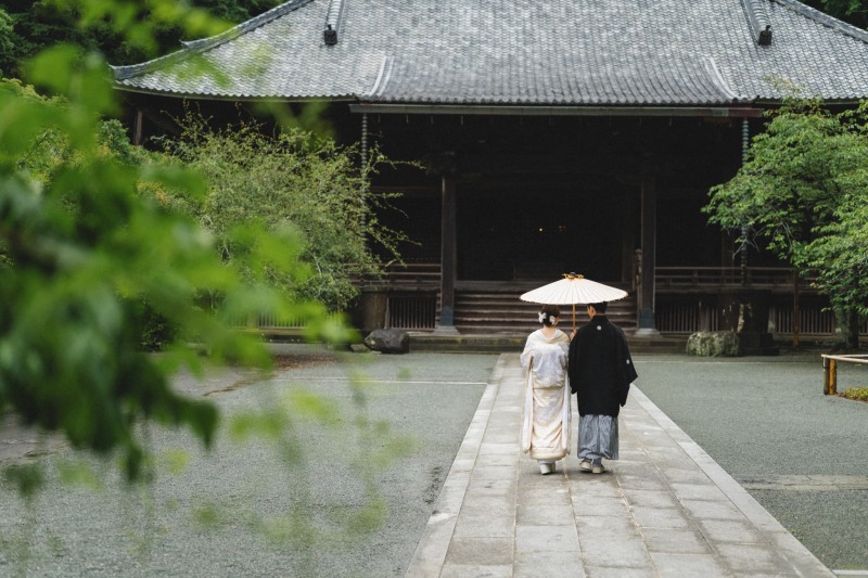 時折差す日傘の影、歴史あるお堂へと続く一本道。