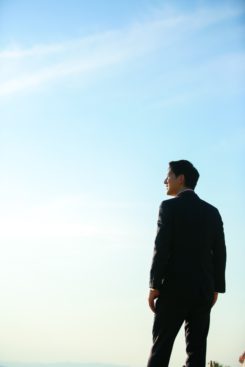 青空を背景にかっこいいご新郎様のソロ写真!