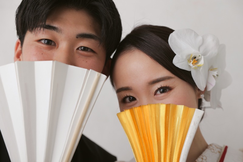 扇子越しの笑顔