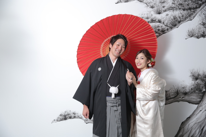 紅い番傘が映える水墨画の前で