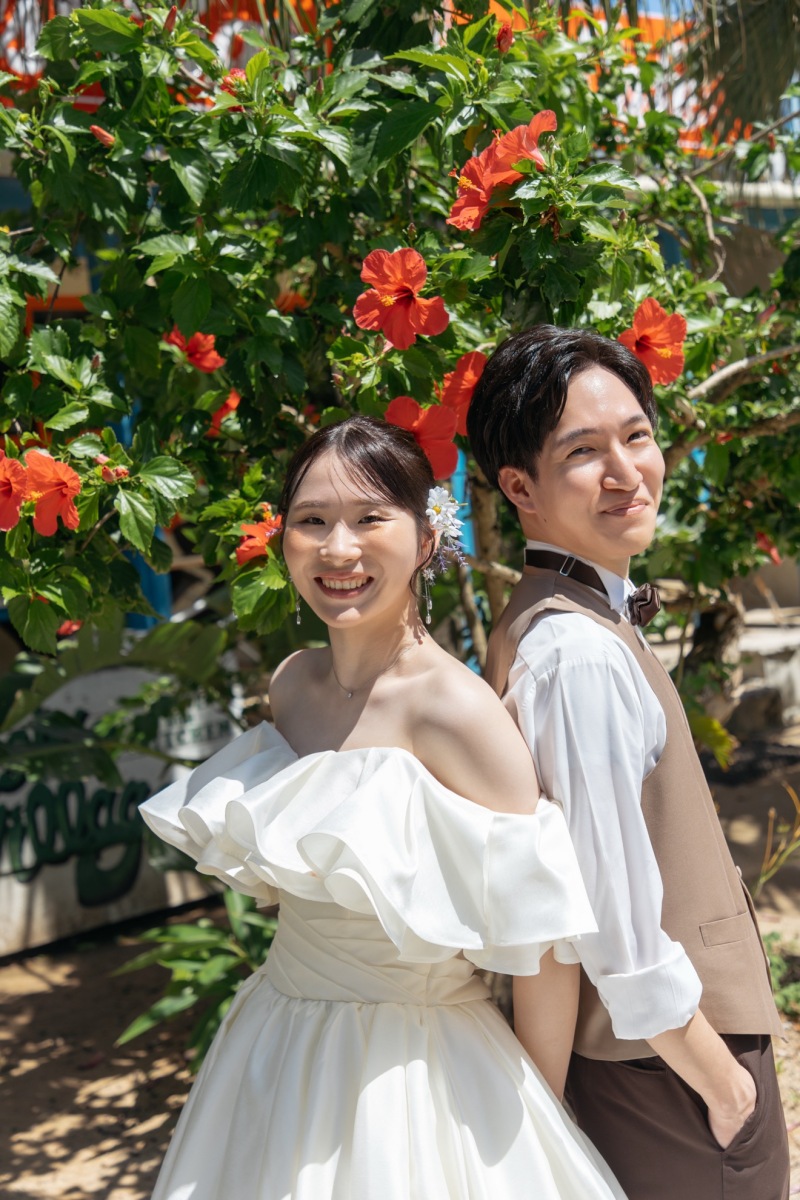 鮮やかな南国の花々に囲まれた笑顔のふたり