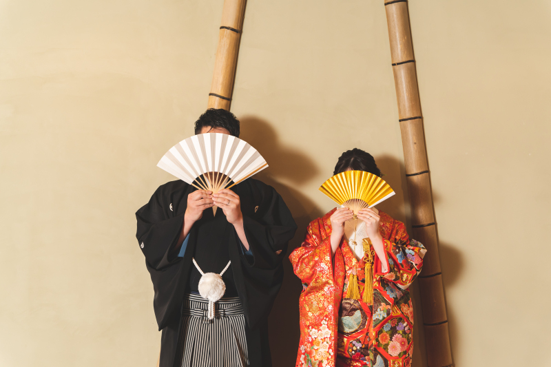 伝統的な色打掛と黒紋服は、和の空間で撮影すると昔にタイムスリップしたような1枚に！扇を使って、お顔を隠すおちゃめさも忘れません。