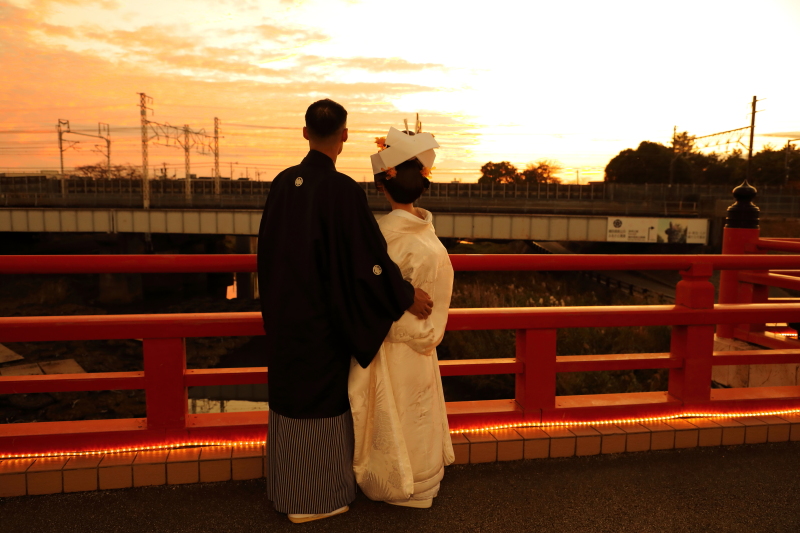 夕焼けの赤い橋で寄り添うふたり