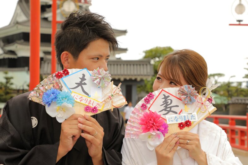 扇で覆う夫婦の初々しさ