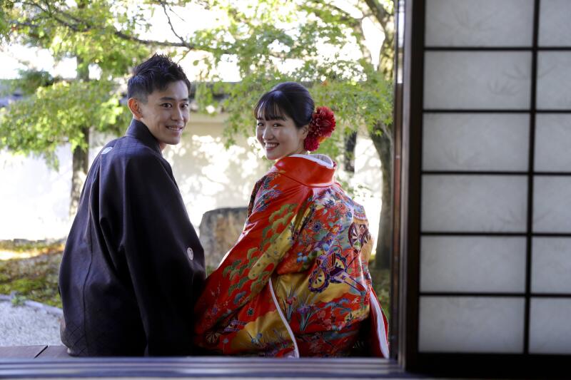 縁側に腰掛けてリラックスした笑顔で