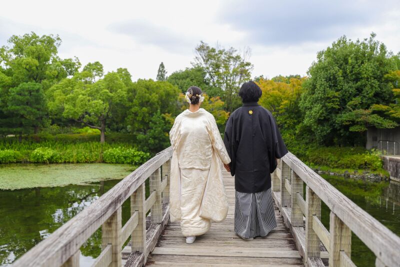 手をつなぎ橋を進む二人の後ろ姿