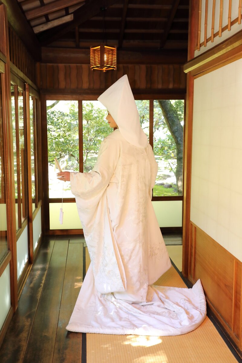 廊下をゆく綿帽子の後ろ姿