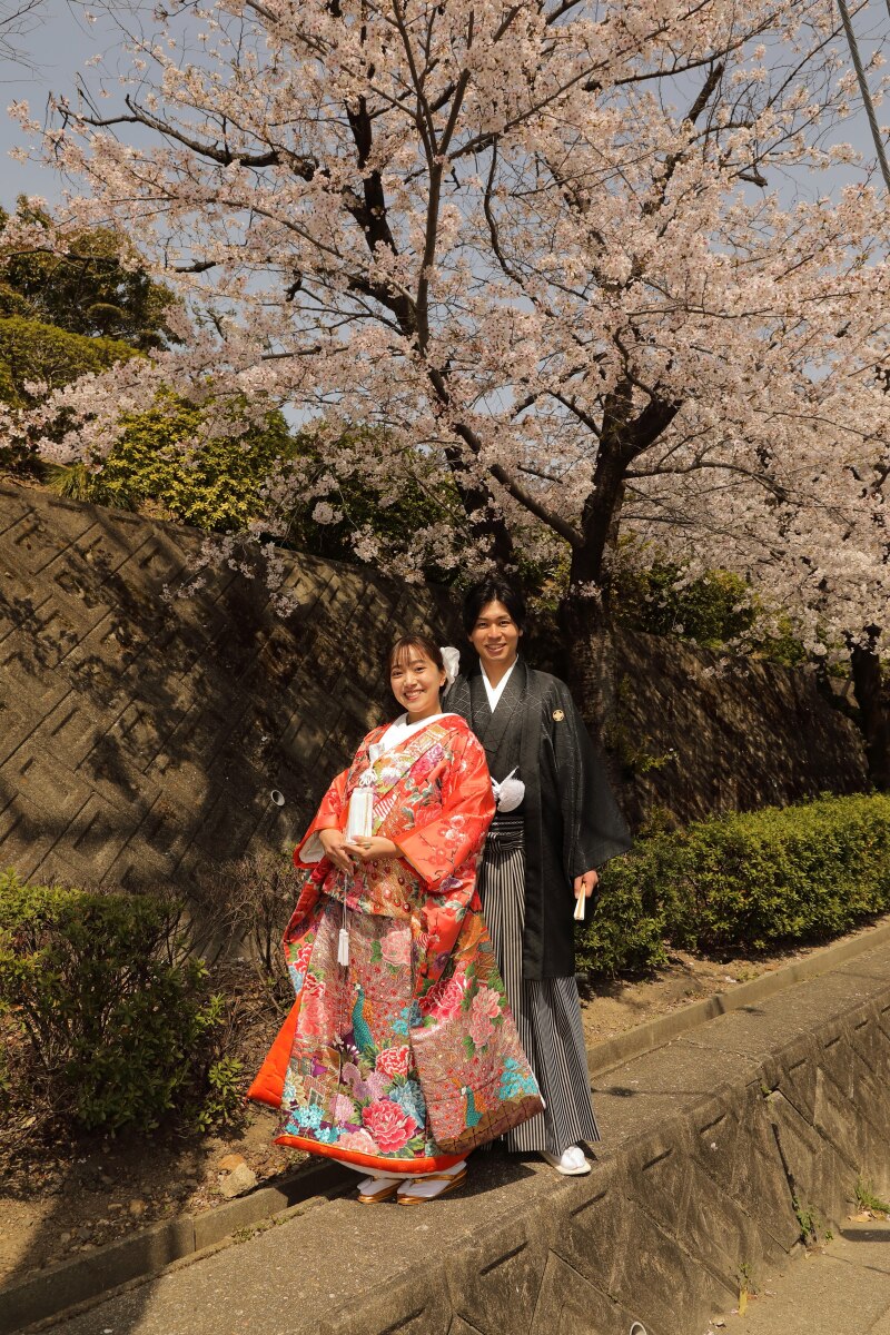 満開の桜の下でニコニコ笑顔で