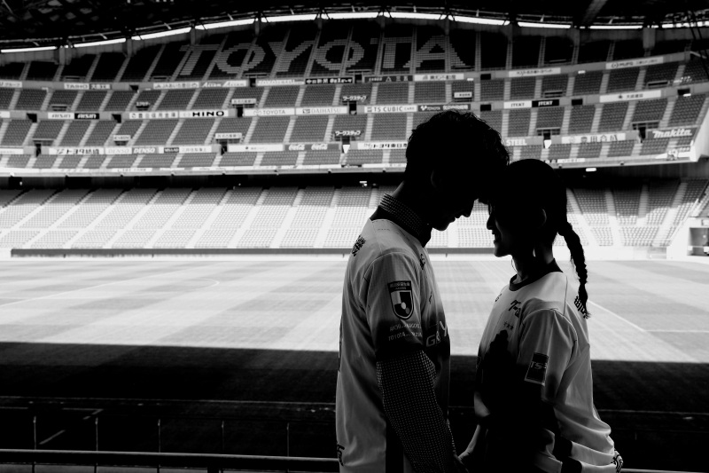 スタンドにておでこコツンポーズをモノクロで