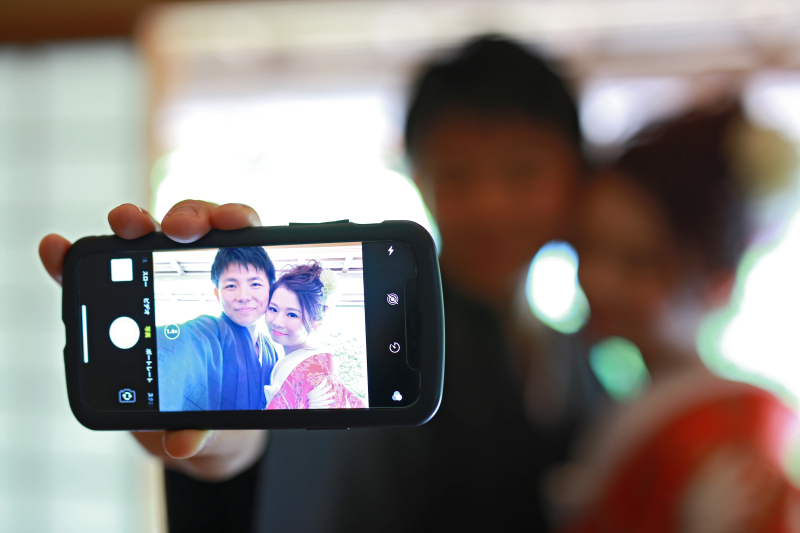 スマートフォン越しに笑顔カット