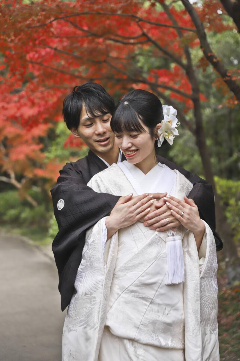 紅葉を背景に後ろからハグして