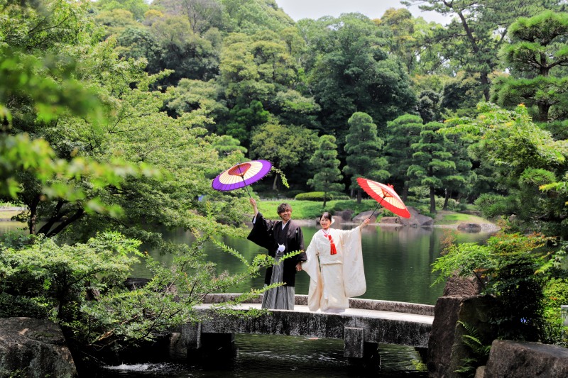 橋の上で和傘を掲げて