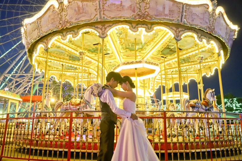メリーゴーランド前で抱き合うカット