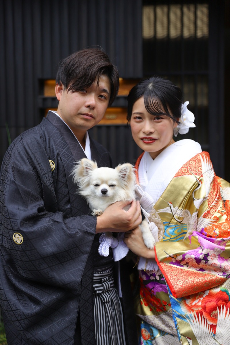 愛犬と店先で微笑む二人