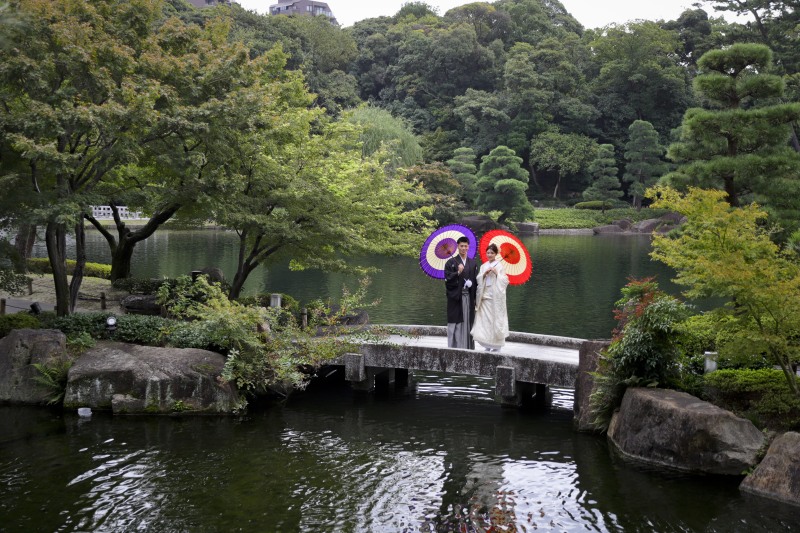 日本庭園をバックに橋の上で