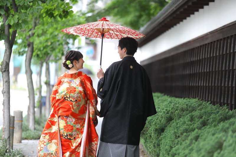 白壁の道にたたずむ後ろ姿