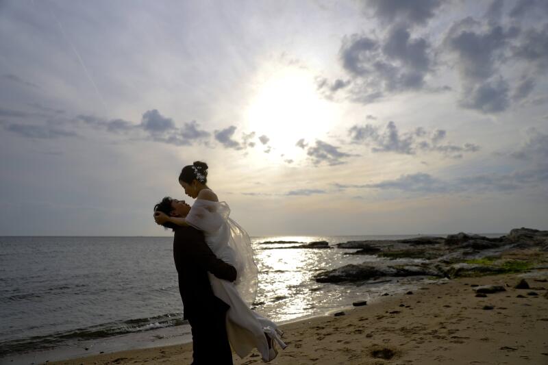 夕日をバックに抱え上げる抱っこカット