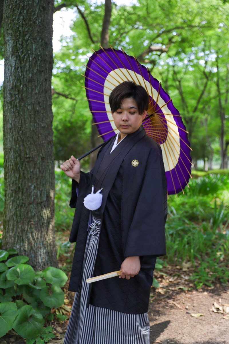 紫の和傘を差す新郎の横顔
