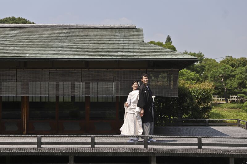 日本家屋をバックに背中合わせで