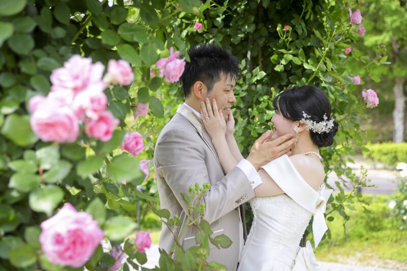 バラ越しにほっぺを触り合うポーズ