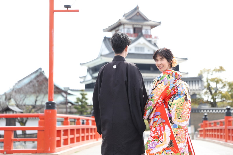 白無垢と色打掛の2着を赤い橋とお城をバックに