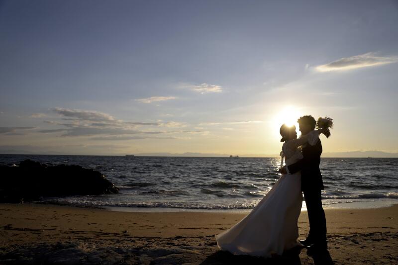 夕日をバックに抱き合うロマンティックなカット