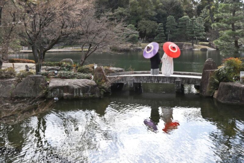 徳川園の池を背景に歩む