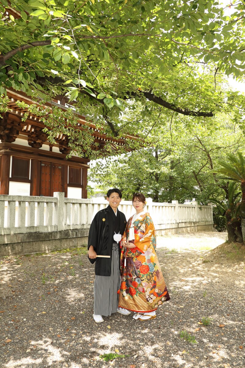 青葉の下で並び立つ晴れやかな二人